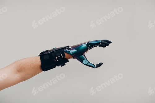 Preview: Disabled man with artificial prosthetic hand close up hand against gray background.