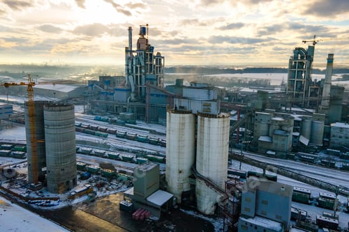 Preview: Aerial view of cement plant with high factory structure and tower crane at industrial production