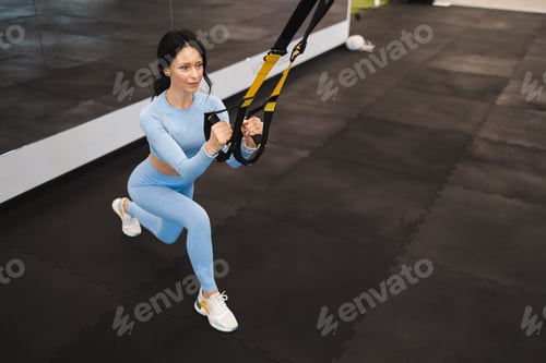 Vista previa: Mujer haciendo ejercicios TRX en el gimnasio