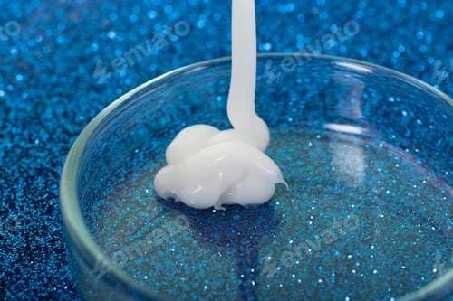 Preview: Closeup photography of white cream dripping in petri dish.