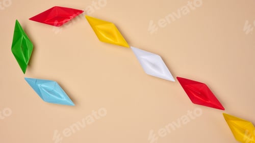 Preview: Multi-colored origami paper boats are arranged in a curved line, symbolizing a path or connection