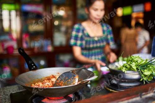 Preview: cooking red thai curry in kitchen selective focus on wok