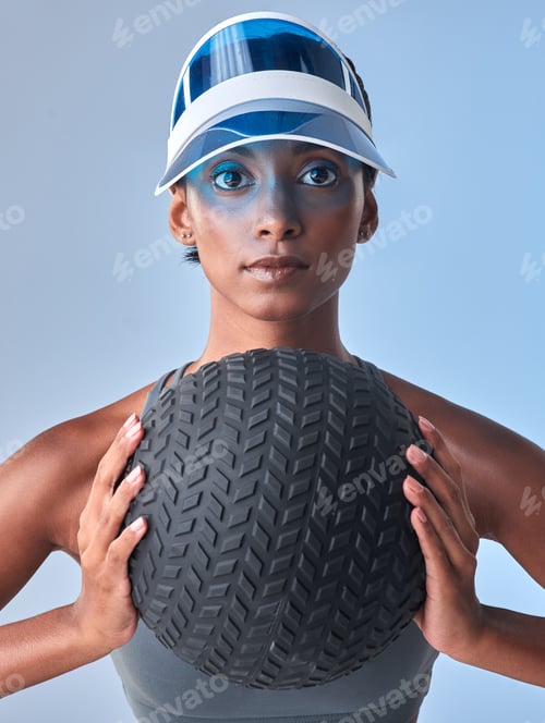 Preview: Studio shot of a fit young woman working out with a medicine ball against a grey background