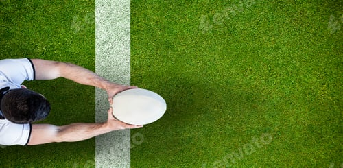 Preview: Composite image of high angle view of man holding rugby ball with both hands