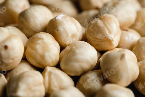 Preview: Background of peeled hazelnuts close-up, macro shot.