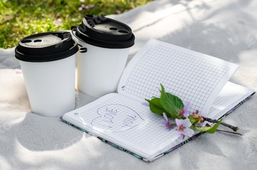 Preview: two paper cups of coffee or tea and a sakura branch on a light blanket