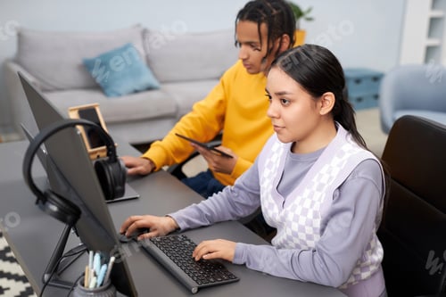 Preview: Two young people writing code in office woman in foreground