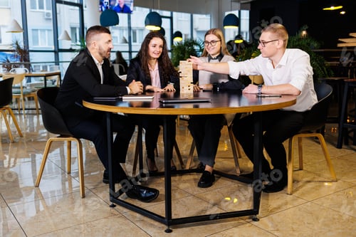 Preview: A company of colleagues in the office during a break plays the board game jenga. Fun board games