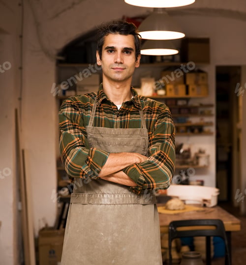 Preview: Handsome young man posing in pottery workshop