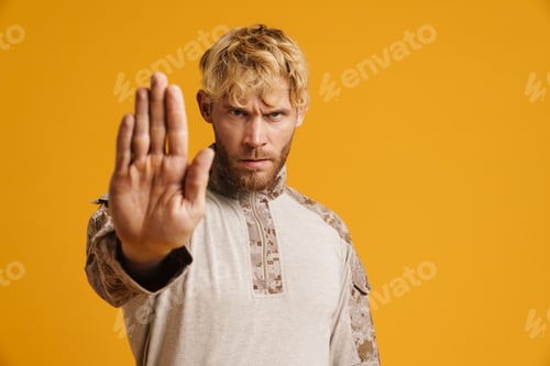 Preview: European military man wearing uniform showing stop gesture at camera