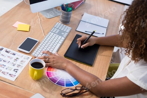 Preview: Female executive working over graphic tablet at her desk