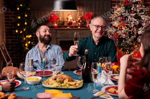 Preview: Smiling man proposing christmas toast at festive dinner