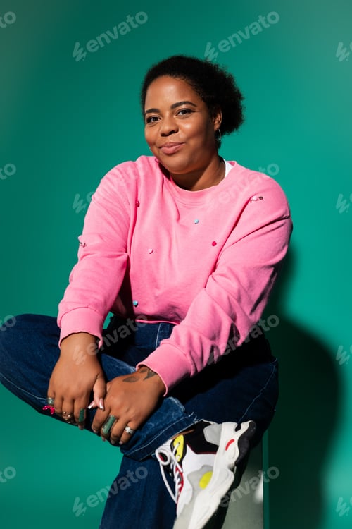 Preview: Stylish plus size woman showcasing trendy autumn fashion in a vibrant studio setting