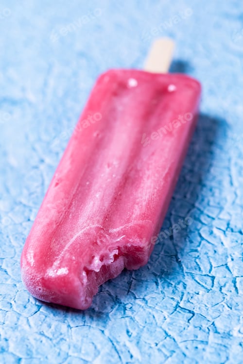 Preview: Red strawberry popsicles on blue background.