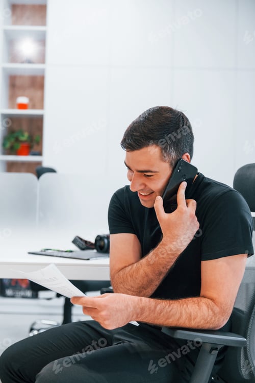 Preview: Man in black clothes have work in the office. Sitting by the table