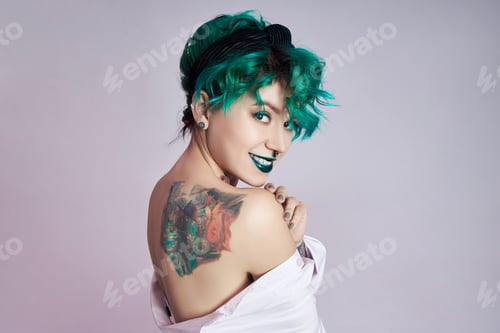 Preview: Woman with creative green coloring hair and makeup, toxic strands of hair. Bright color curly hair