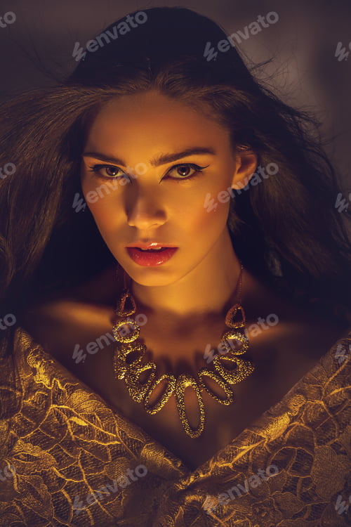 Preview: beautiful young woman with necklace in golden light