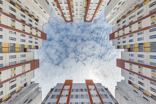Preview: view up from ground to blue sky among skyscrapers, look at house from bottom up