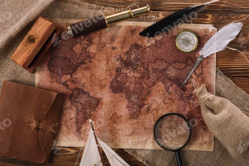 Preview: top view of old world map near telescope, nib and compass on wooden surface