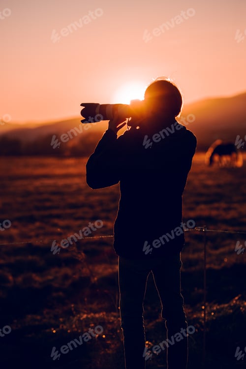 Preview: Man shooting on camera beautiful landscape between hills