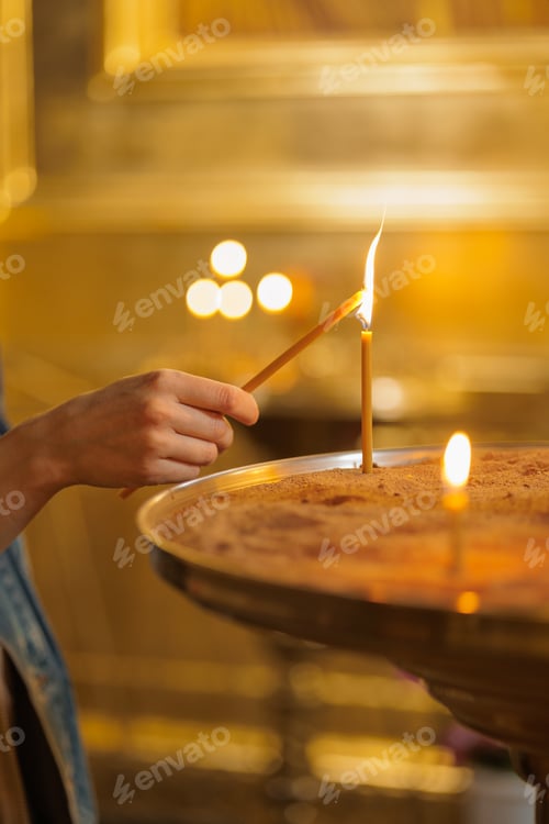 Preview: woman in the temple puts candles and prays. religion and spiritual growth. the search for truth and