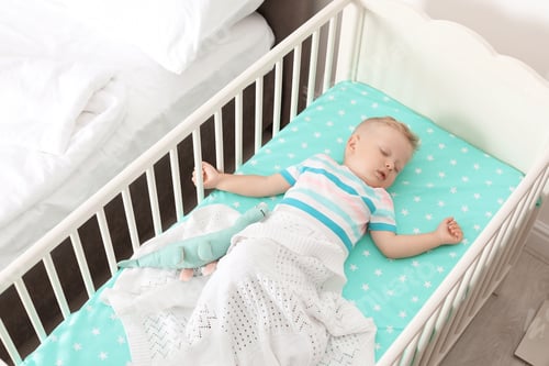 Preview: Cute little child sleeping in crib at home