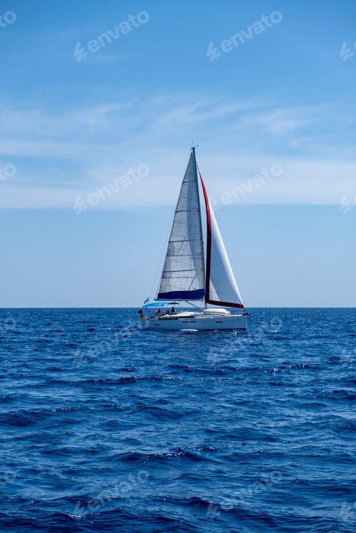 Preview: Sailing boat with open white sails, blue sky and rippled sea background