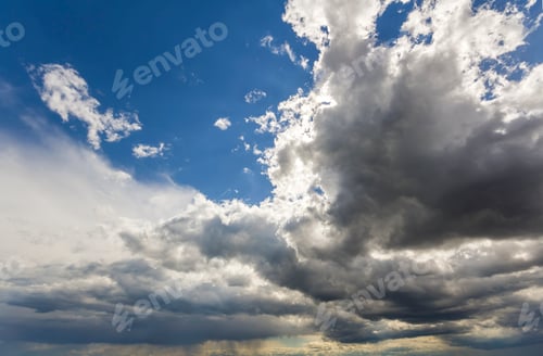 Preview: Close-up beautiful view of colorful white gray dark wide clouds lit by sun spreading against deep