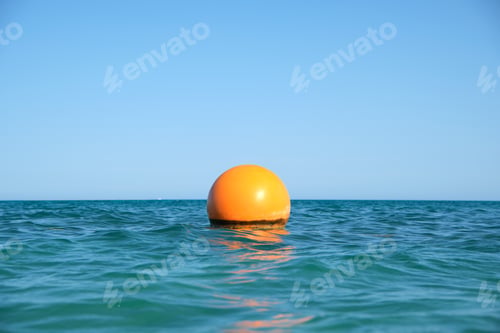 Preview: Yellow buoy floating on sea surface as marker for swimming restriction in deep water