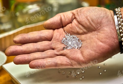 Preview: Jewelry production. Fixer holds diamonds on the palm before fixing