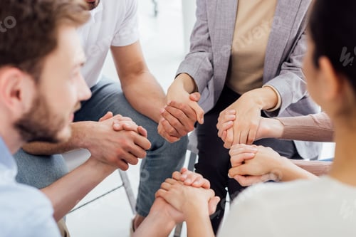 Preview: cropped view of people holding hands during group therapy session