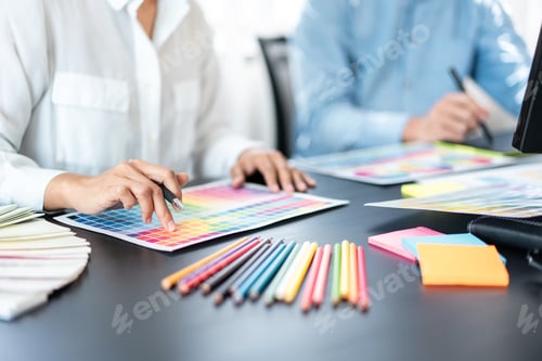 Preview: Two creative graphic designer team working on color selection and drawing on graphic tablet
