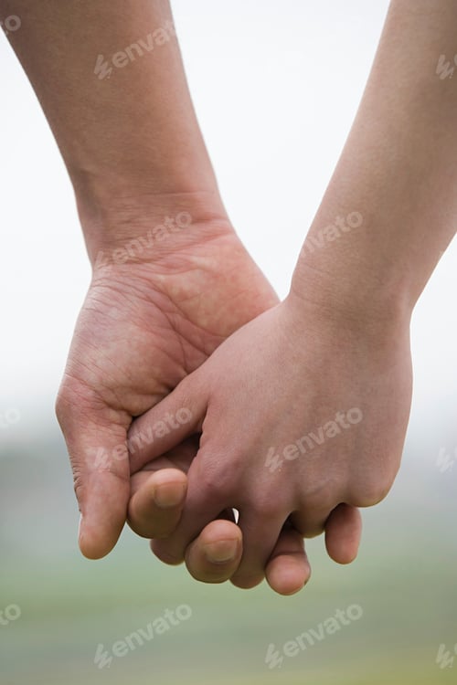 Preview: Two people holding hands tightly.
