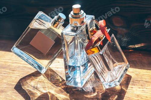 Vista previa: Several bottles with perfume in rays of sunshine on wooden table