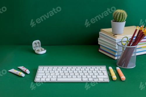 Preview: Colorful school supplies on a green background
