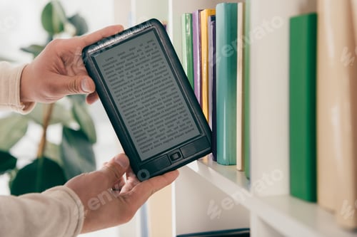 Preview: cropped view of man taking ebook from bookshelf
