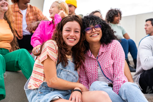 Preview: Happy playful multiethnic group of young friends bonding outdoors