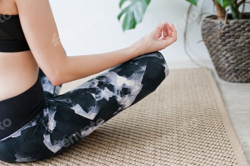 Preview: Young woman meditating on the jute rug at home with green monstera plant, feel calm, women’s health