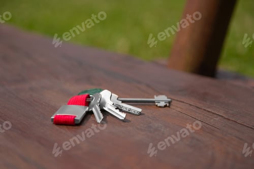 Preview: Keys forgotten on wooden bench outdoors. Lost and found