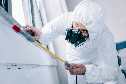 Person Wearing Protective Suit Spraying a Surface