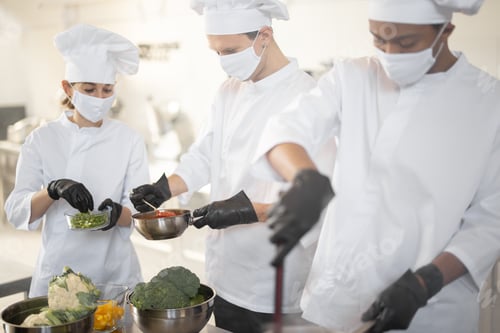 Preview: Multiracial team of chef cooks cooking together in the kitchen