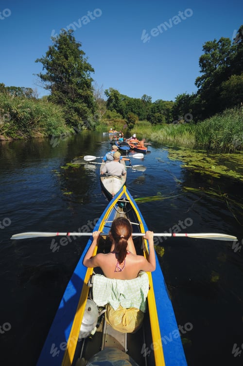 Preview: a group of tourists are kayaking on a small river in summer