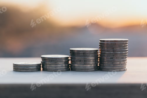 Preview: Close up money stack coin under sunset background. Business finance growth concept.