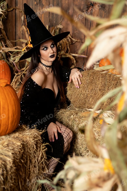 Preview: young girl in the image of a witch, wearing a black hat and a black dress with a make-up