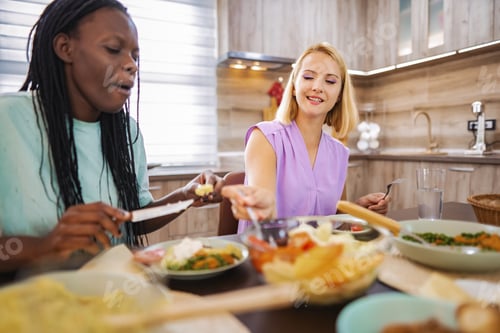 Preview: Friends enjoying a vibrant meal in a cozy kitchen setting