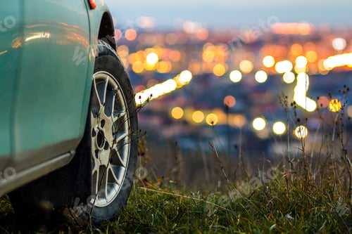 Preview: Modern car with blurred bright city lights behind