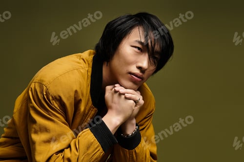 Preview: Charming young man showcasing stylish attire in an artistic studio environment