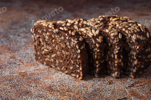 Preview: Fresh black bread with sunflower seeds on an old rusty table