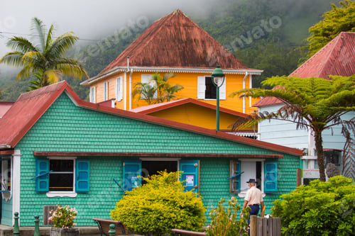 Preview: Colorful houses nestled in a lush mountain village with a person enjoying a leisurely walk.