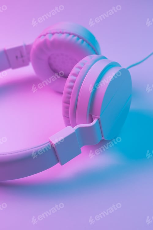 Preview: Retro 90s style photo of white stylish wireless headphone in neon lights. Music concept.